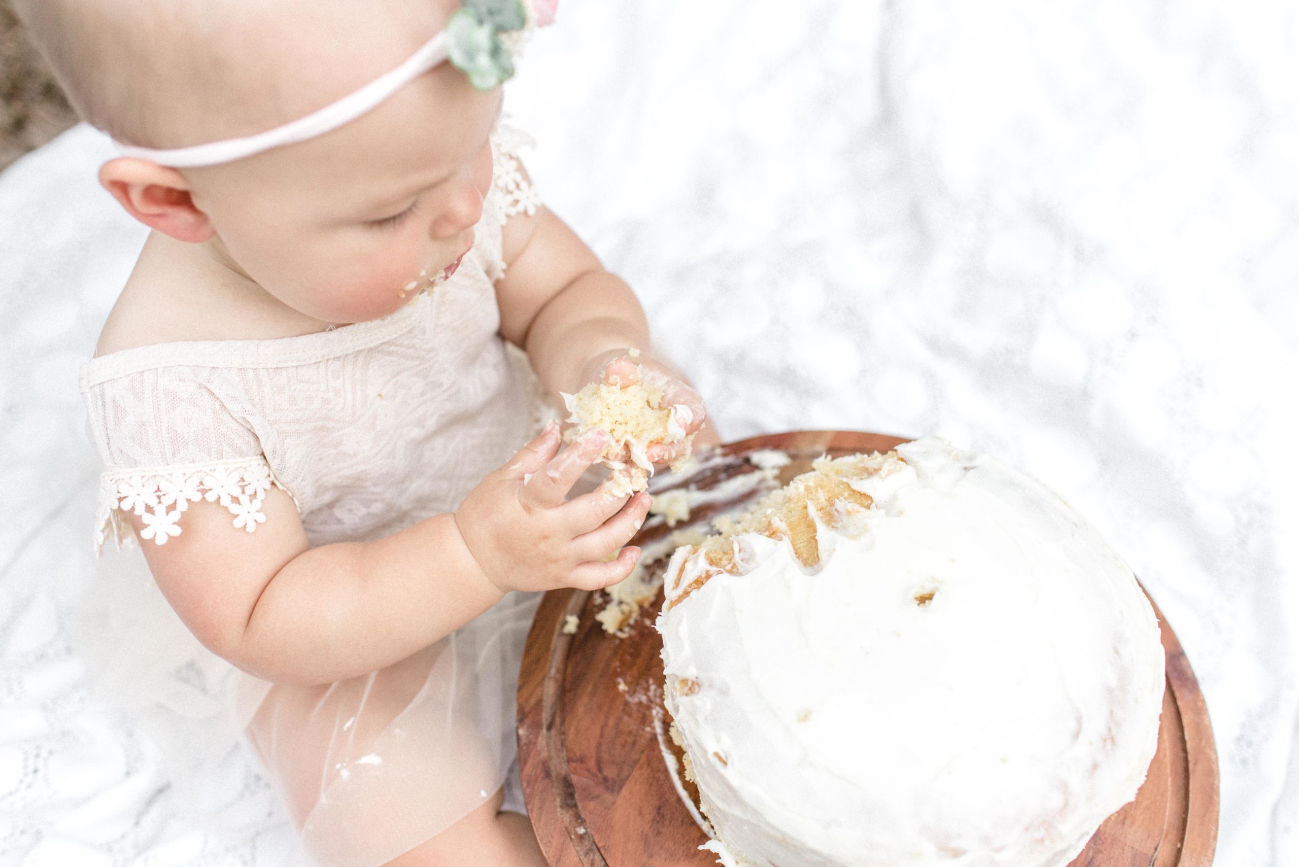 Baby girl smashing a cake for her first birthday.