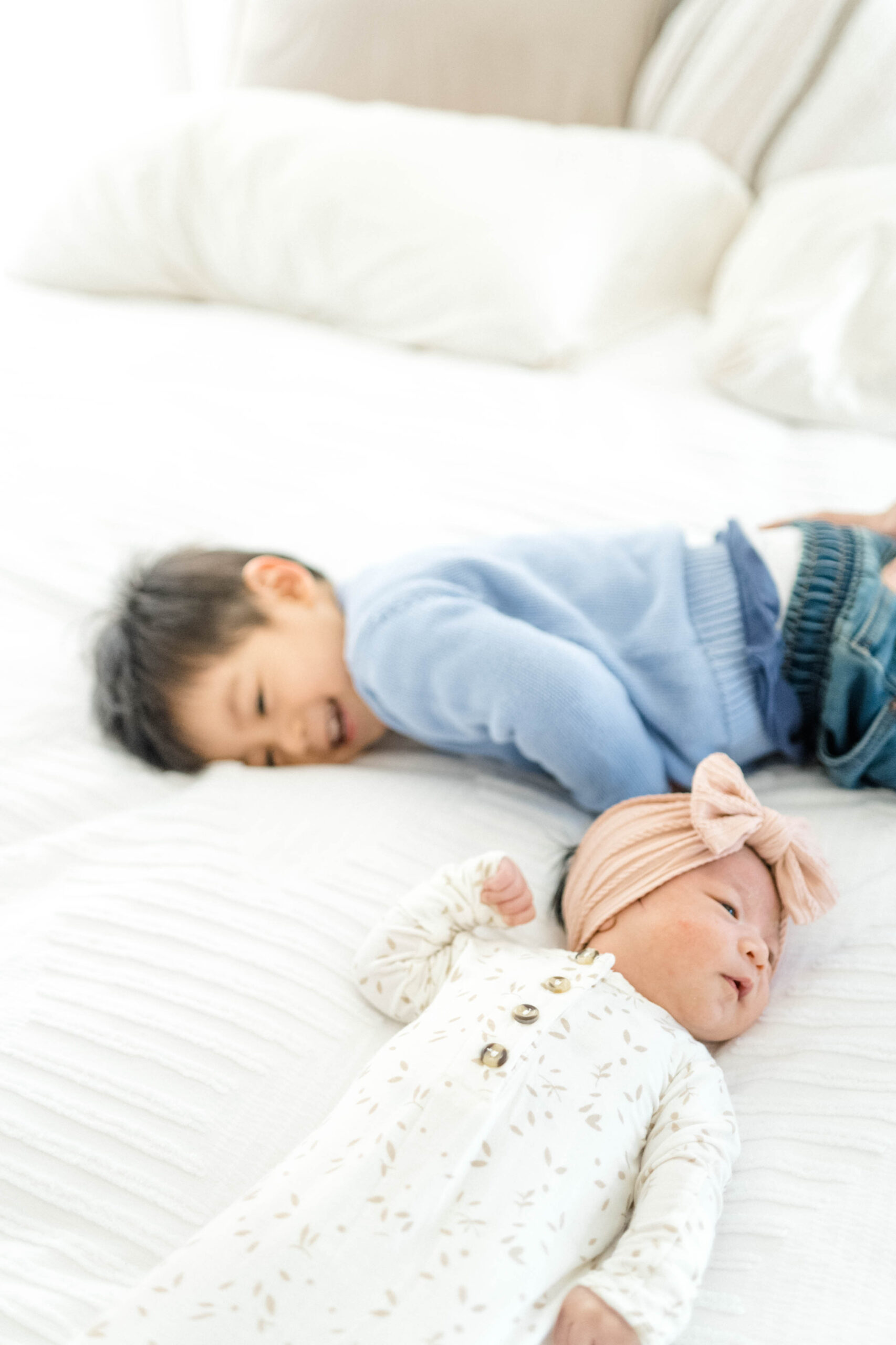 Big brother and little sister playing around during their newborn photography session in the Annapolis, Maryland area.